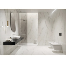 Helles Badezimmer mit Marmorfliesen, Waschtisch, Spiegel, Dusche, Toilette und Bidet.