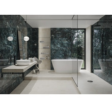 Modernes Badezimmer mit Badewanne, Waschtisch und grünen Marmorfliesen.