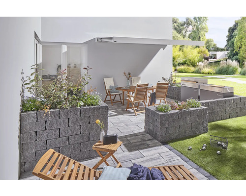 Terrasse mit Gartenmöbeln, Grill und Hochbeeten aus Stein