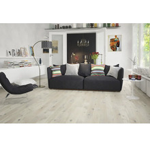 Wohnzimmer mit Sofa, Sessel, Stehlampe und hellem Holzboden