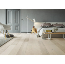 Heller Wohnraum mit Holzboden, Bett und Stühlen