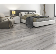 Heller Schlafraum mit Laminatboden in Holzoptik, Bett, Sessel und Nachttisch