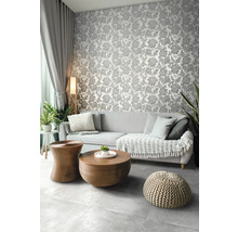 Wohnzimmer mit floral gemusterter Tapete, Sofa und Holztischen