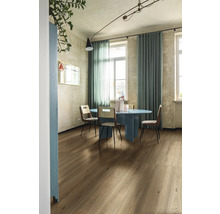 Esszimmer mit Holzboden, blauem Tisch und Stühlen unter einer Deckenleuchte.