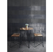 Raumansicht mit dunklen Wandfliesen und einem Holztisch mit Hockern