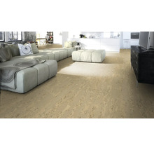 Heller Wohnraum mit Korkboden, Sofa und Küchenzeile im Hintergrund.