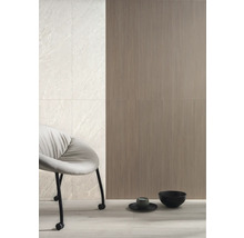 Wandgestaltung mit Fliesen in Steinoptik und geriffelter Oberfläche, kombiniert mit einem Stuhl und dekorativen Schalen.