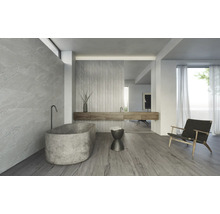 Badezimmer mit grauen Fliesen, freistehender Badewanne, Waschtisch und Stuhl