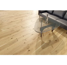 Heller Holzboden mit Astlöchern in einem Wohnzimmer mit Couch und Tisch.