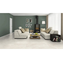 Wohnzimmer mit Sitzgruppe, Kaminofen, Couchtisch und keramischen Bodenfliesen.