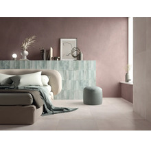 Helles Schlafzimmer mit Bett, Hocker und Wandverkleidung aus Fliesen