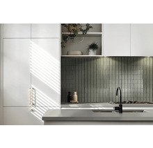 Moderne Küche mit weißen Schränken, grauer Arbeitsplatte und Mosaikfliesen als Spritzschutz.