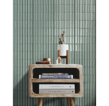 Wandgestaltung mit rechteckigen Fliesen, einem Holztisch und Dekorationsgegenständen.