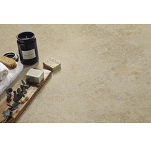 Dekoratives Badezimmerambiente mit beiger Fliese, Kerze, Seife und Handtüchern