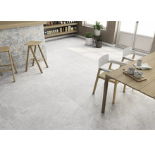 Heller Raum mit Bodenfliesen in Steinoptik, Barhockern und Esstisch.