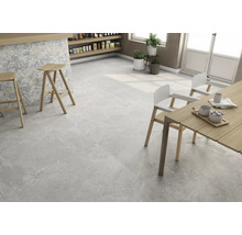 Heller Raum mit Bodenfliesen in Steinoptik, Tresen mit Barhockern und Esstisch mit Stühlen