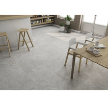 Heller Raum mit grauen Bodenfliesen, Holztisch und Stühlen