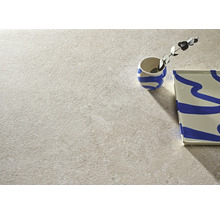 Nahaufnahme einer hellen Bodenfliese mit Struktur, kombiniert mit dekorativen Elementen