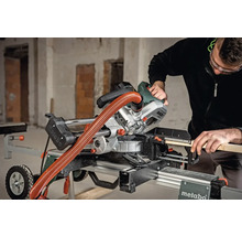 Eine Person bedient eine Metabo Kapp- und Gehrungssäge auf einem Arbeitstisch.