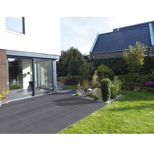 Garten mit Terrasse aus Steinplatten, angrenzend an ein modernes Wohnhaus