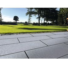 Außenbereich mit Pflastersteinen und Rasenfläche