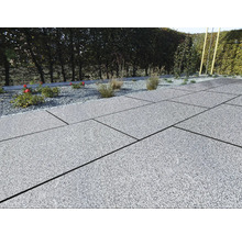 Terrasse mit grauen Steinplatten und Kiesbeet mit Pflanzen