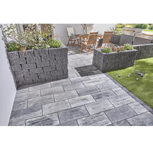 Terrasse mit Pflastersteinen und Pflanzkästen aus Stein