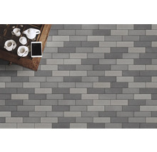 Verlegung von Pflasterklinkern in Grau- und Anthrazittönen mit Teegeschirr und Tablet