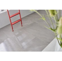 Heller Raum mit Bodenfliesen in Steinoptik und roter Leiter