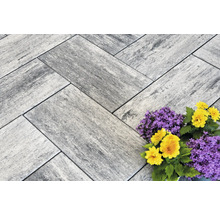 Verbundpflastersteine im Fischgrätenmuster mit Blumenarrangement