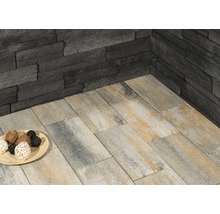 Wandverkleidung aus Stein und Bodenplatten im Außenbereich.