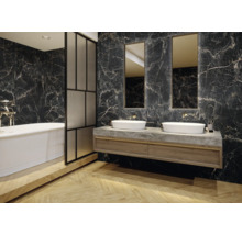 Badezimmer mit Badewanne, Waschtisch, Spiegel und Marmorfliesen