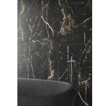 Badezimmerwand mit Fliesen in Marmoroptik, kombiniert mit einer freistehenden Badewanne und Armatur