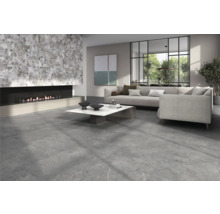 Wohnzimmer mit Steinfliesenboden, Kamin und grauer Couch