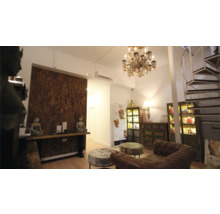 Innenaufnahme eines hellen Raumes mit Möbeln, Dekorationen und einer Wendeltreppe