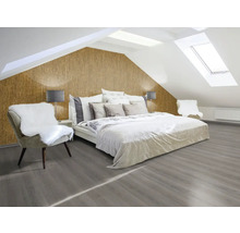 Helles Schlafzimmer mit Dachschrägen, Korktapete, Bett, Stuhl und grauem Holzboden