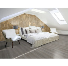 Schlafzimmer im Dachgeschoss mit Doppelbett, Stuhl und Korktapete