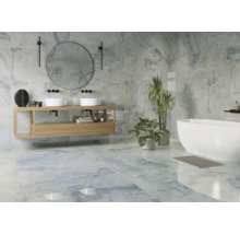 Helles Badezimmer mit Waschbecken, Spiegel, Badewanne und blauen Fliesen