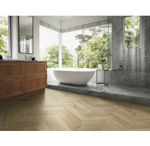 Helles Badezimmer mit Badewanne, Waschtisch und Holzfußboden in Fischgrätmuster