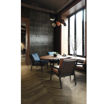 Ein heller, organisierter Raum mit einem runden Tisch, umgeben von Stühlen, und Fliesen an der Wand