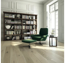 Wohnzimmer mit Bücherregal, Sessel und Fußhocker