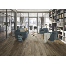 Heller Wohnraum mit Couch, Sesseln, Bücherregal und Holzboden