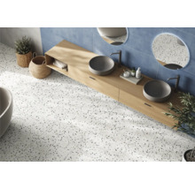 Badezimmer mit Doppelwaschtisch, runden Spiegeln, blauen Wandfliesen und Bodenfliesen in Terrazzo Optik