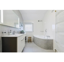 Badezimmer mit Waschtisch, Spiegel, Badewanne und Heizkörper