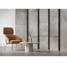 Helles Interieur mit Sessel, Beistelltisch und Wandpaneelen in Betonoptik