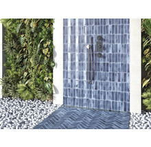 Badezimmer mit blau gefliestem Duschbereich, Pflanzenwand und Kieselsteinen