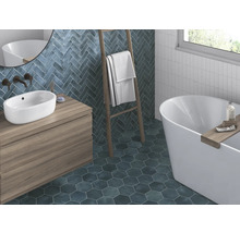 Badezimmer mit Waschtisch, Badewanne, Handtuchleiter und Wand- sowie Bodenfliesen