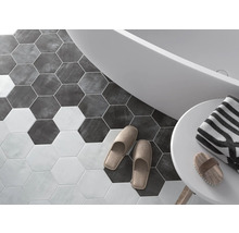 Badezimmer mit sechseckigen Bodenfliesen, Badewanne, Handtuch und Hausschuhen