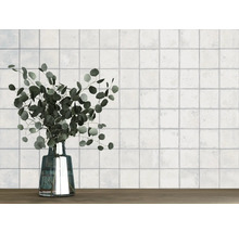 Wand mit quadratischen Fliesen und eine Vase mit Eukalyptus auf einem Holztisch