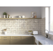 Küchenszene mit Küchenschränken, Spüle, Fliesen und Dekorationen auf einem Regal